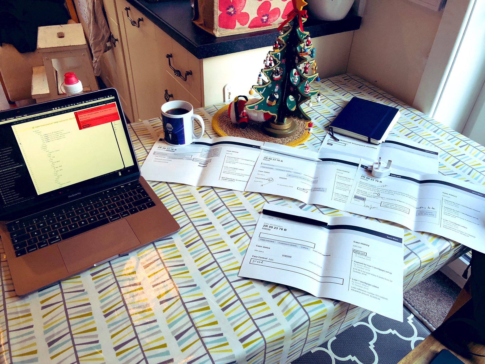 The table in my kitchen with prints outs of some design work scattered on it